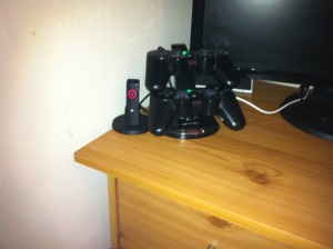 Photo of PS3 controller Docking Station with 2 controllers in it and the official Sony Bluetooth Headset